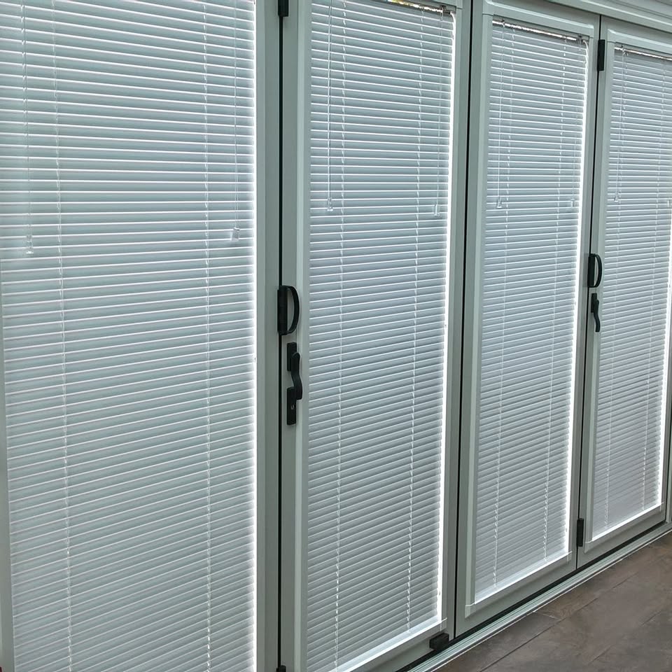 White venetian blinds fitted in a run of patio doors